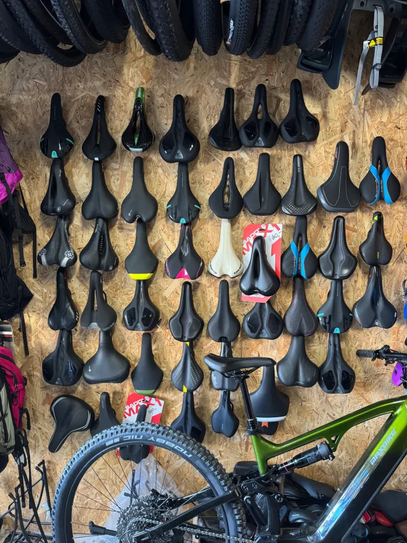 Deska s desítkami cyklistických sedel, dole elektrokolo